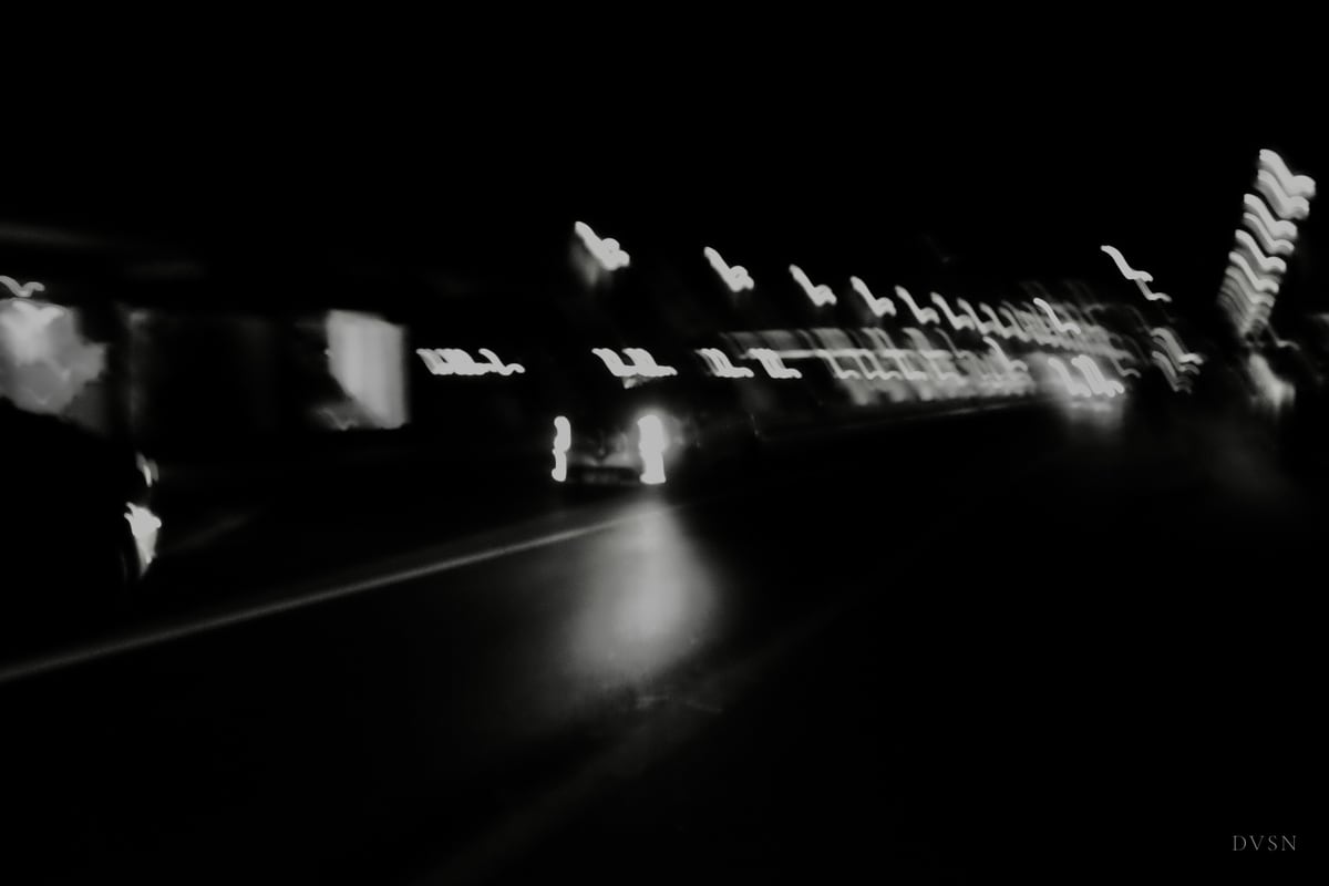 Streaks of city lights blurred by movement in the night.